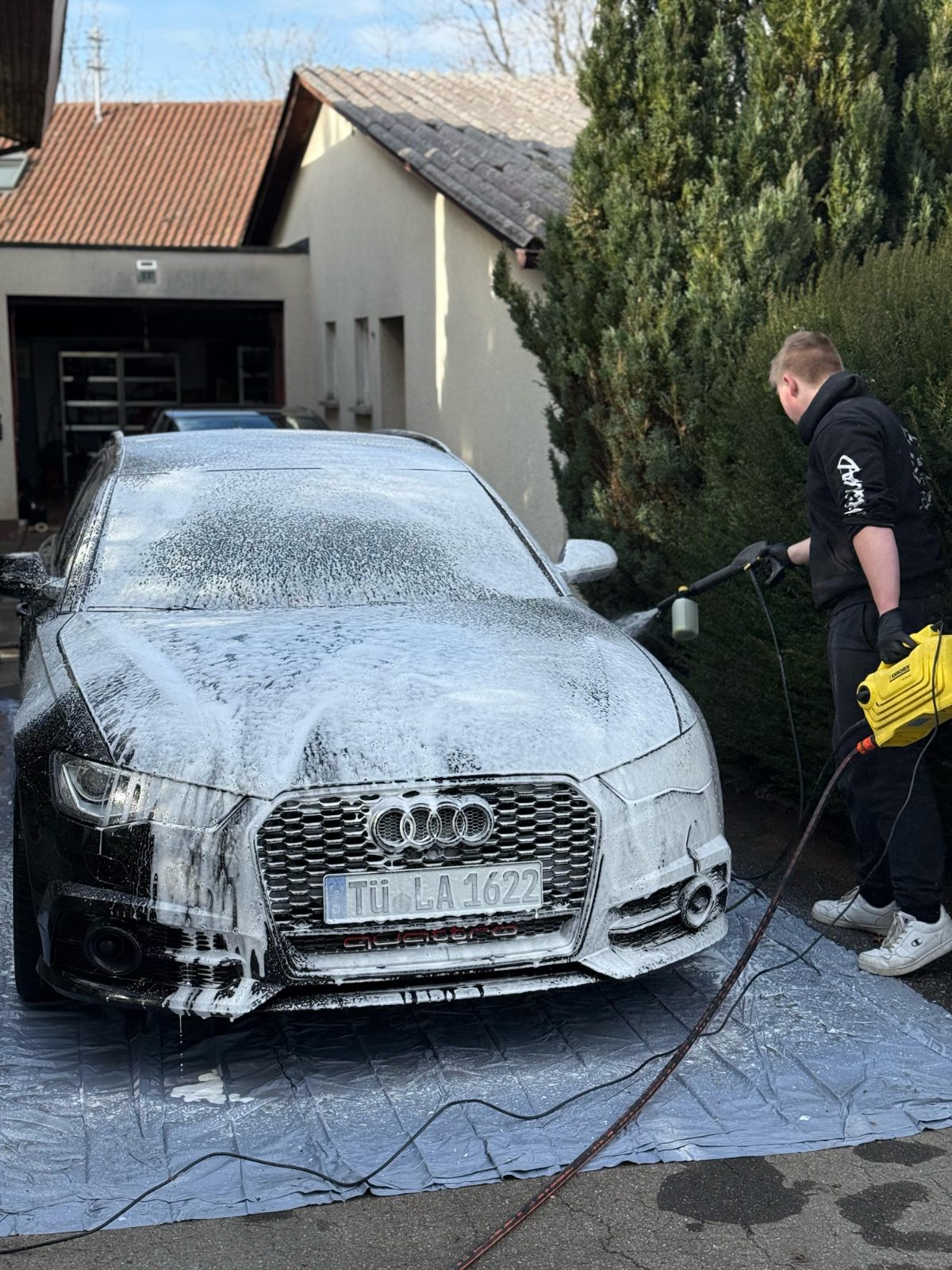 Mobile Aufbereitung eines Audi A6 mit Schaumvorwäsche vor einem Wohnhaus